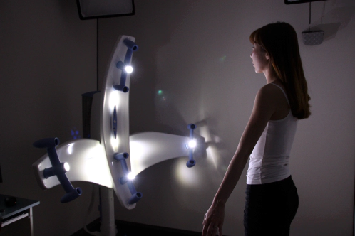 Woman using 3D breast scan machine for Korean breast augmentation surgery.