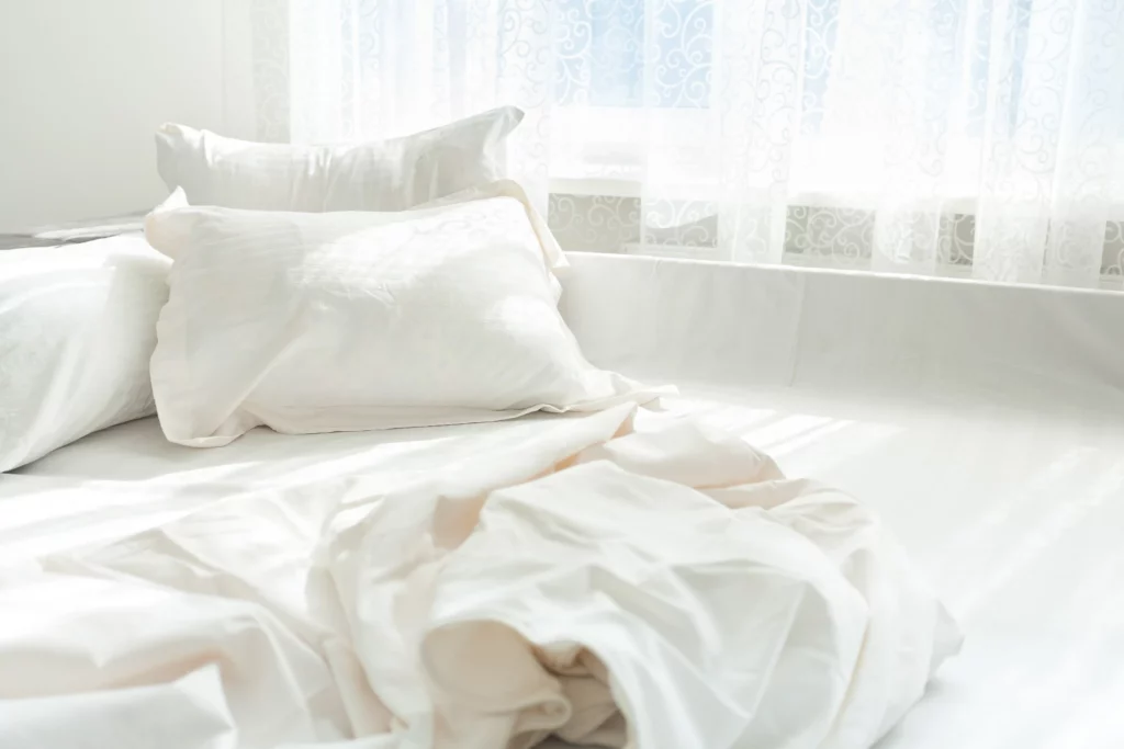 Breast lift recovery rest concept image showing a clean, comfortable bed with soft pillows and bedding, representing proper rest, sleep, and a calm recovery environment after breast lift surgery.