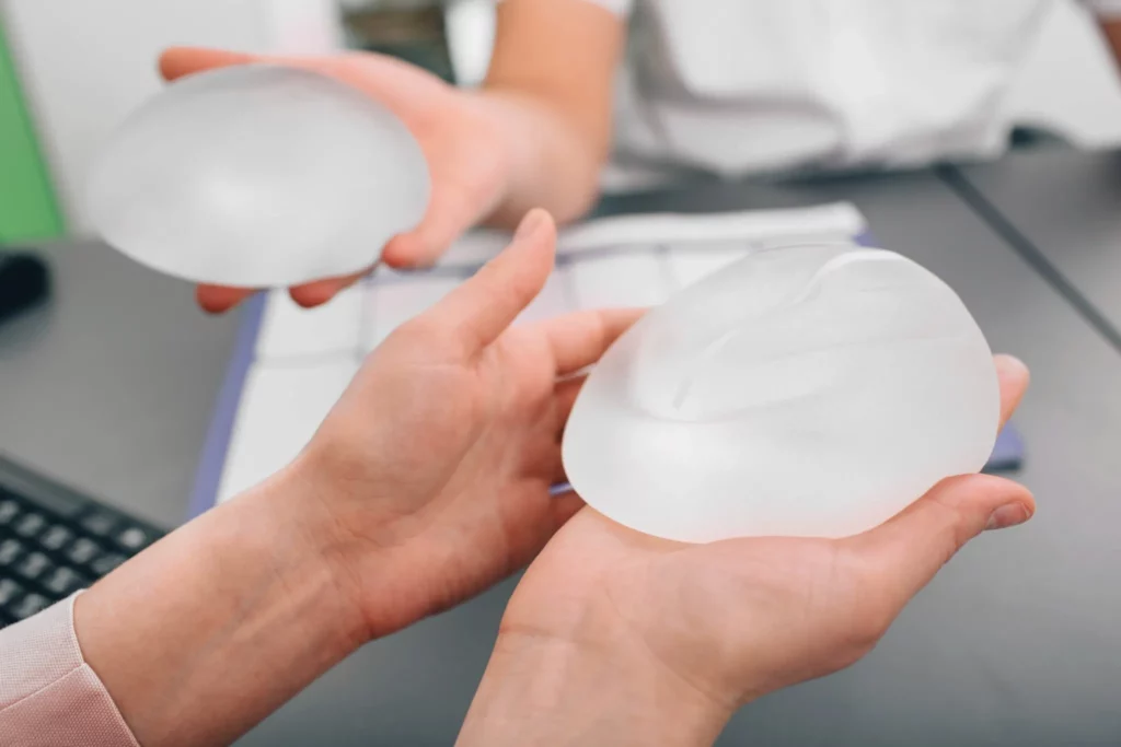 Image of nurses holding implant after removing them for a breast implant rupture case.