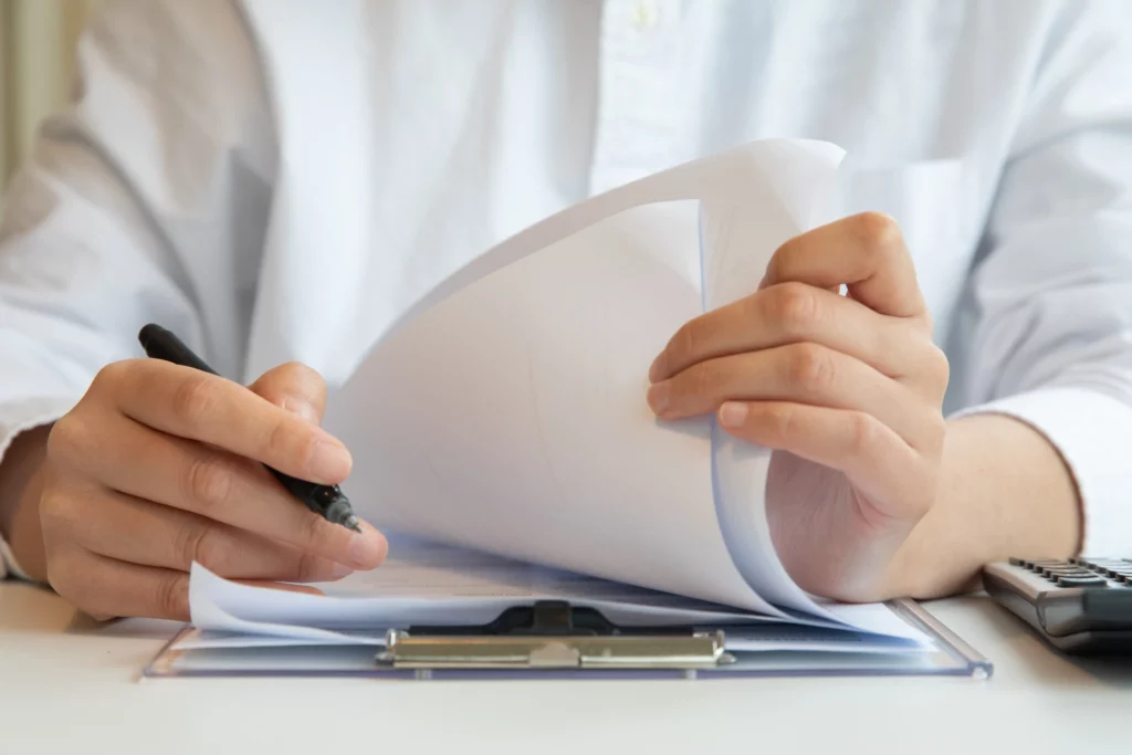 Doctor reviewing and signing patient consent documents before a mini facelift procedure, symbolizing surgical planning and consultation process.