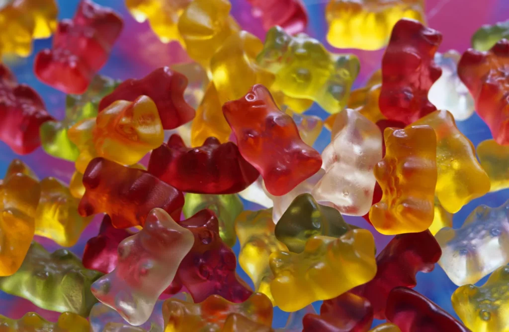 Colorful gummy bear candies — sticky, chewy sweets are among the foods to avoid after salivary gland reduction because they stress the jaw and stimulate saliva.