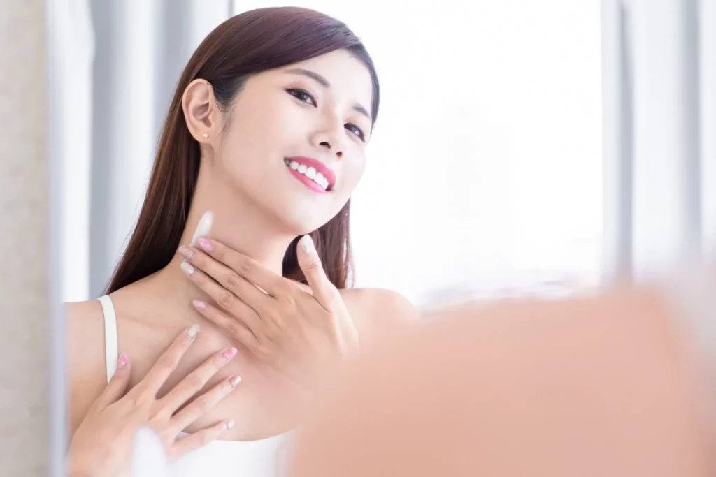 Woman applying skincare along her neck, part of the daily habits that help maintain neck lifting procedure results