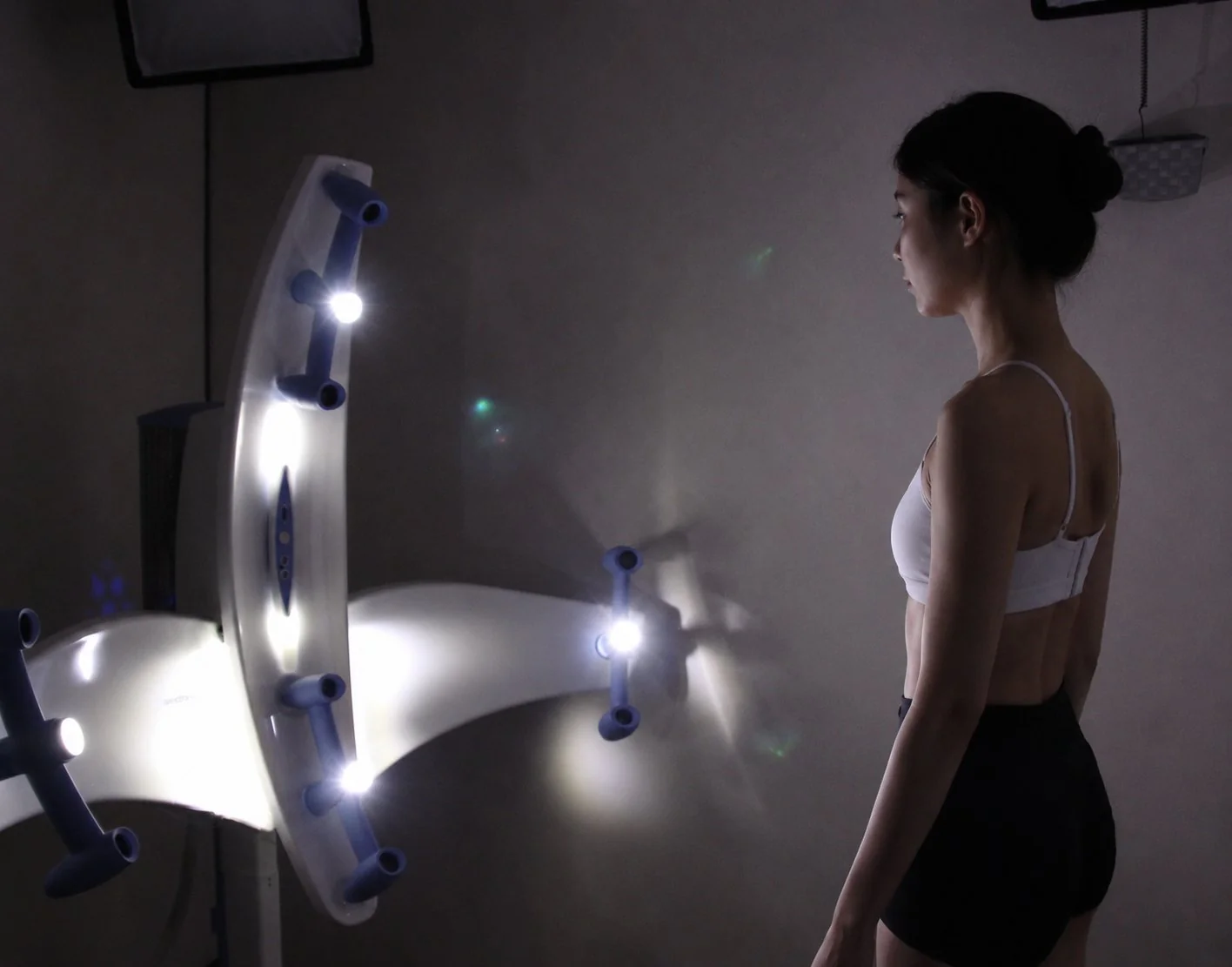 Woman standing in front of a 3D body scanner for a surgical planning scan before endoscopic breast augmentation