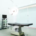 Operating room at MINE Plastic Surgery in Seoul with surgical table and overhead lights, cover image for how long does a mini facelift last