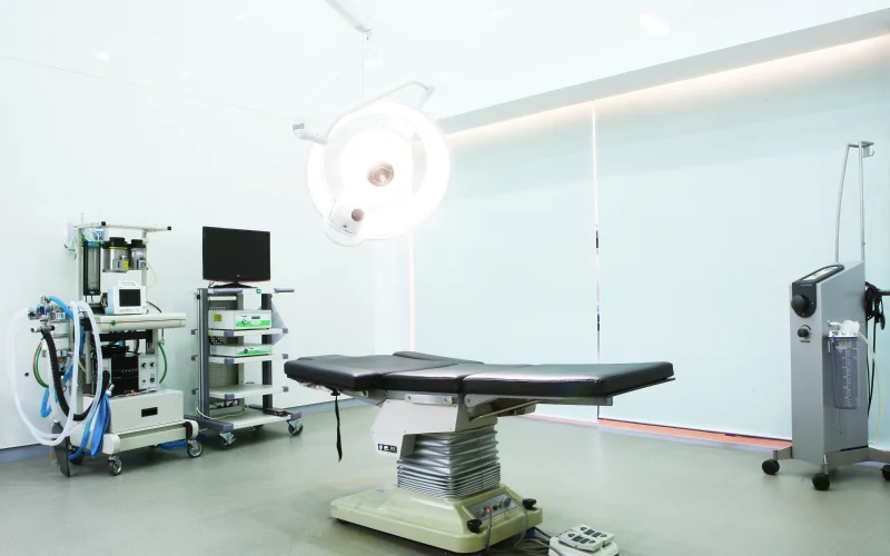 Operating room at MINE Plastic Surgery in Seoul with surgical table and overhead lights, cover image for how long does a mini facelift last