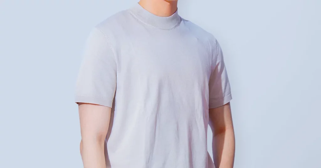 Man in a light short-sleeve T-shirt, concerned about nipples showing through clothing and considering male nipple reduction (model photo)
