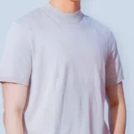 Man in a light short-sleeve T-shirt, concerned about nipples showing through clothing and considering male nipple reduction (model photo)