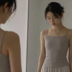 Woman with a slim frame looking at her reflection, considering motiva implants for a slim frame