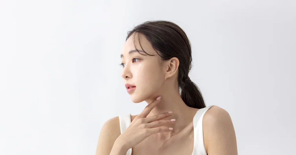 Parotid gland botox vs masseter botox: woman in side profile touching her neck just below the jawline