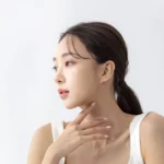 Parotid gland botox vs masseter botox: woman in side profile touching her neck just below the jawline
